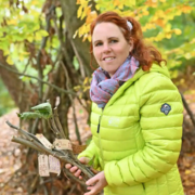 Porträt von Pilgerbegleiterin Carmen Petrus im Wald im Herbst, umgeben von buntem Laub.
