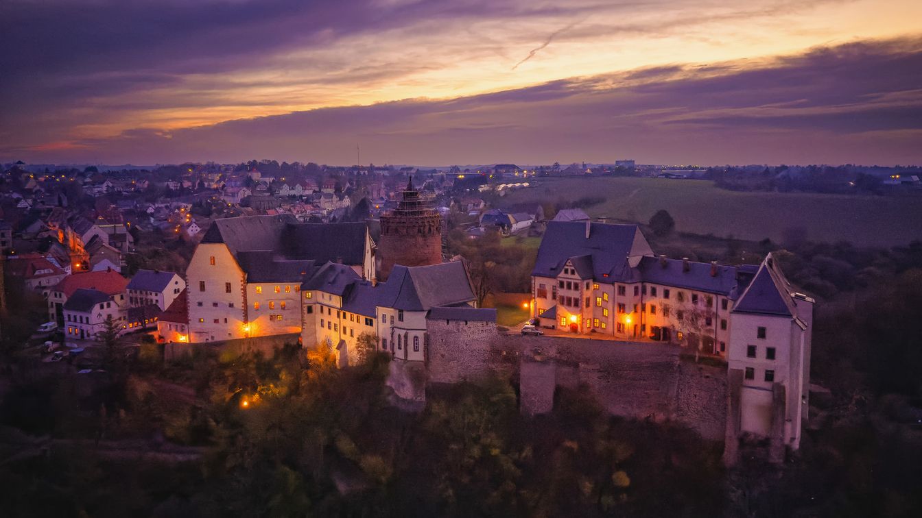 Die Drohnenaufnahme zeigt Burg Mildenstein in Leisnig zu einer romantischen Abendstimmung beim verdeckten Sonnenuntergang.