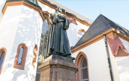 Lutherdenkmal vor der St. Nicolaikirche in Döbeln, Darstellung von Martin Luther auf dem Kirchenvorplatz.