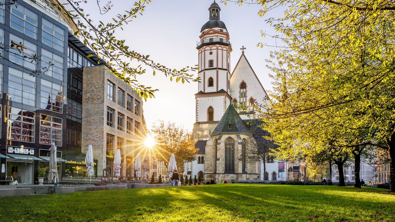 Die Thomaskirche leuchtet im Sonnenlicht.
