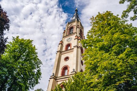 Der Kirchturm leuchtet vor blauem Himmel.